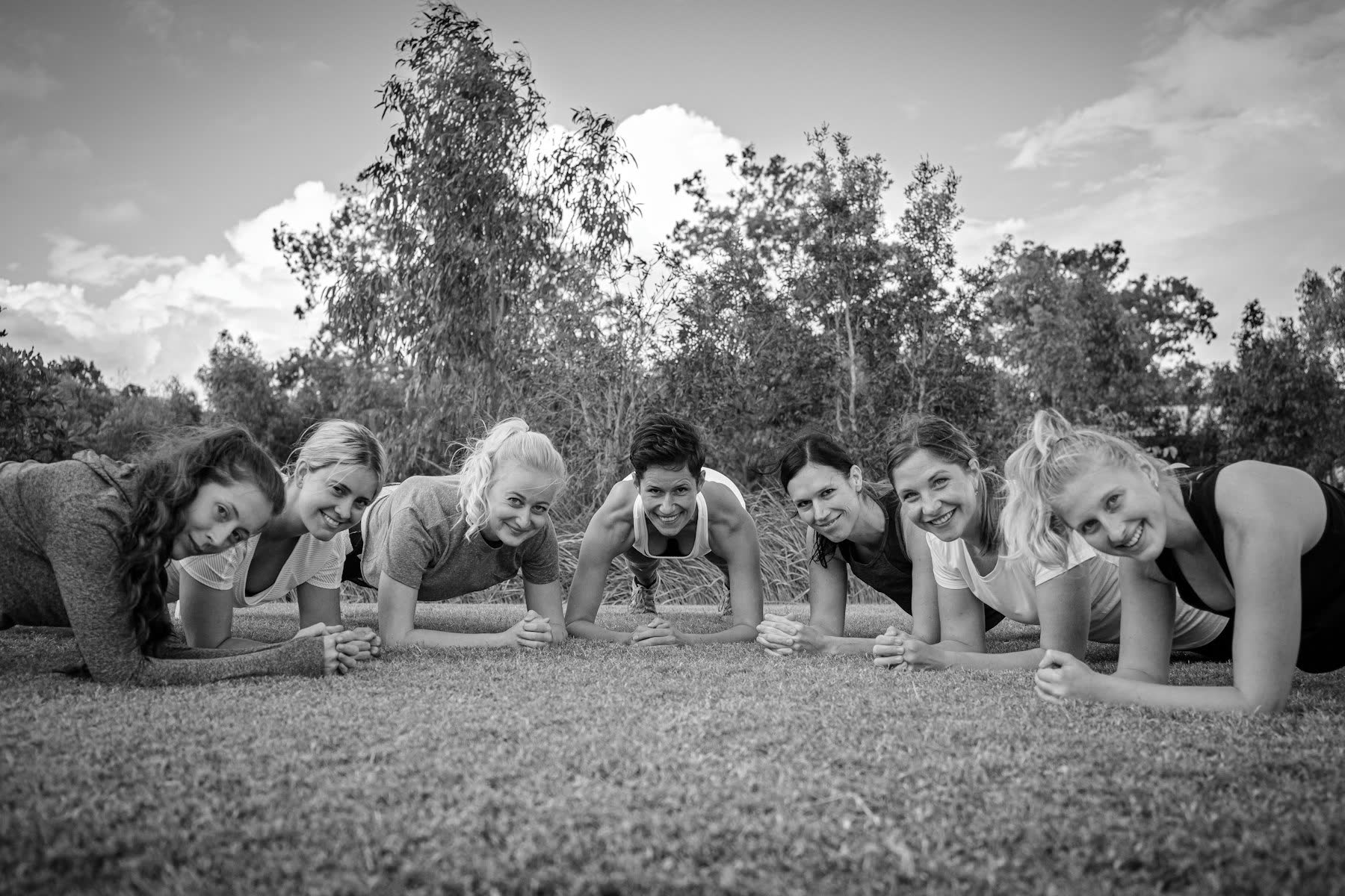 Group holding a plank together outdoors