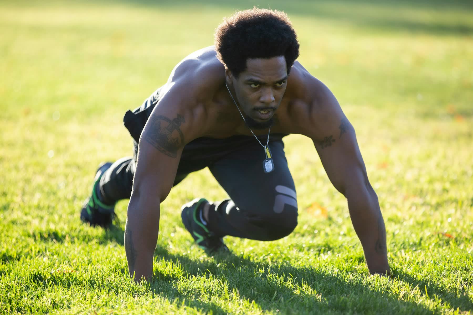 Athlete doing a bear crawl on grass